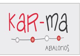 Texto: "KAR-MA ABALORIOS". Letras y cuentas rojas y blancas sobre fondo gris.