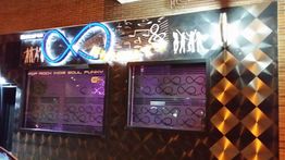Fachada de bar con letrero de infinito y estilos musicales: pop, rock, indie, soul, funky.