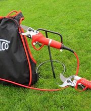 Rucksack mit "Felco"-Logo, verbunden mit elektrischen Gartenscheren, auf grünem Rasen.