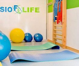 Sala de fisioterapia con pelotas, colchonetas y símbolo de accesibilidad.