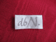 Etikett mit handgeschriebenem "d6/N" auf rotem Stoffhintergrund.