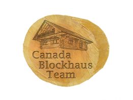 Holzscheibe mit Gravur: "Canada Blockhaus Team" und ein Blockhaus-Skizze.