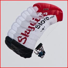 Skydiver with a black, white, and red parachute, branded with "Skydivestore.com".