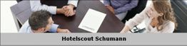 Personen am Tisch besprechen Vertrag, darunter Text: "Hotelscout Schumann".