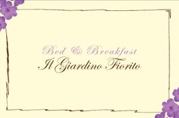 "Scritta 'Bed & Breakfast Il Giardino Fiorito' con bordo floreale viola su sfondo beige."
