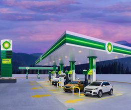 Estación de servicio BP al atardecer con coches blancos y amarillos en las bombas.