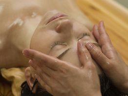 Person erhält entspannende Gesichtsmassage mit Öl in einem Spa.