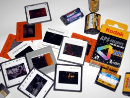 Dias und Filmrollen auf einem Tisch, teils von Kodak und Porst.