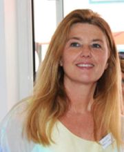 Eine Frau mit langen Haaren lächelt in die Kamera.