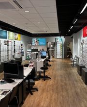 Een brillenwinkel met vitrines vol brillen en enkele bureaus voor klantenservice.