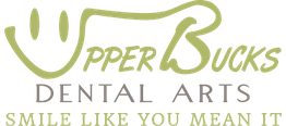 Logo of Upper Bucks Dental Arts with smiley face and "Smile Like You Mean It" tagline.