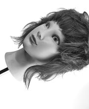 Testa di manichino con capelli ondulati corti, in bianco e nero.