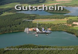 Gyrokopter über einem See und Wald mit Schrift "Gutschein, Genießen Sie die schöne Aussicht".