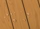 Water droplets on a wooden surface forming a smiling face shape.