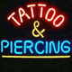 Leuchtendes Neon-Schild mit der Aufschrift "Tattoo & Piercing" in Rot und Blau.