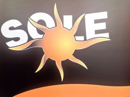Illustrazione di sole arancione con scritta "SOLE" su sfondo nero.