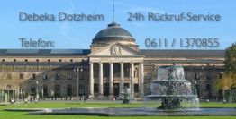 Gebäude mit Säulen, großer Brunnen im Vordergrund, Text: "Debeka Dotzheim, 24h Rückruf-Service".