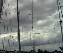 Segelboote im Hafen bei bewölktem Himmel.