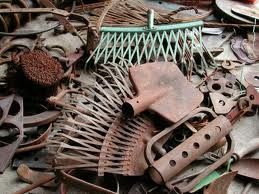 Rostige alte Gartengeräte liegen auf einem Haufen.