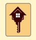 Key shaped like a house with a window, on a tan background.
