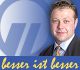 Mann im Anzug vor einem Logo mit dem Text "besser ist besser".