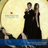 Personen in eleganter Kleidung posieren vor Energetix-Werbung mit goldener Hintergrundwand.