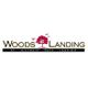 Logo of Woods Landing with a red tree silhouette and birds, text: "At Historic Mays Landing".
