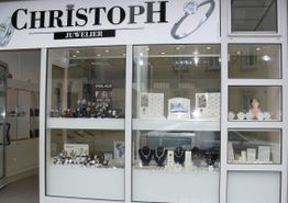 Schaufenster von Juwelier Christoph mit Schmuck und Uhren, einschließlich Halsketten und Ringen.