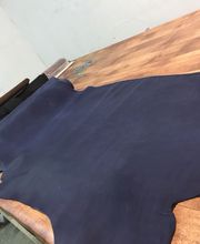 Cuero azul extendido sobre una mesa de madera en una sala de trabajo.