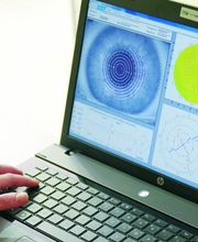 Persona usando una laptop con gráficos de análisis ocular en la pantalla.