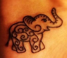 Ein stilisiertes Elefantentattoo mit geschwungenen Mustern auf heller Haut.