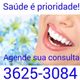 Sorriso com dentes brancos, flores ao fundo, texto: "Saúde é prioridade! Agende sua consulta".