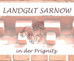 "Ziegelwand mit 'Landgut Sarnow in der Prignitz' und Pferdemotiv in der Mitte."