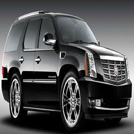 Black SUV with chrome wheels and a sleek design, parked on a gray background.