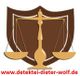 Waage über einem braunen Schild mit Text "www.detektei-dieter-wolf.de" am unteren Rand.