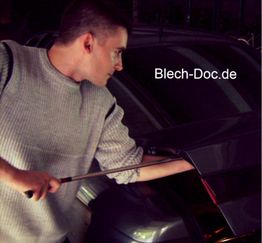 Ein Mann arbeitet mit Werkzeug an einem Auto. Text: "Blech-Doc.de".