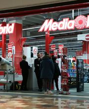 Ingresso di un negozio MediaWorld con persone che fanno acquisti e personale vicino all'entrata.