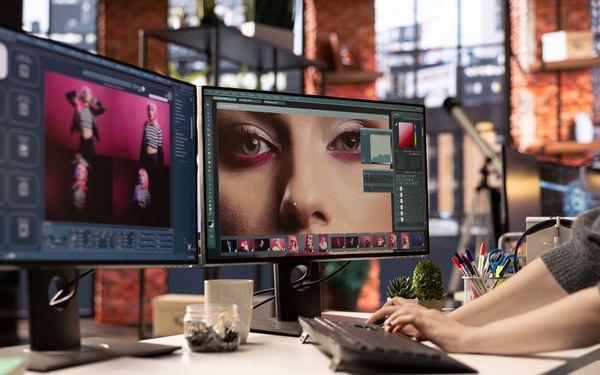 Ein Fotograf bearbeitet Fotos eines Models, die er gerade aufgenommen hat, in seinem Studio.