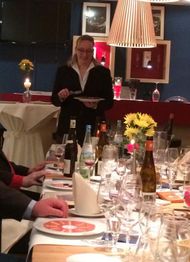 Eine Kellnerin serviert in einem Restaurant an einem Tisch mit Gläsern und Flaschen.