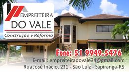 Imagem de uma residência moderna com informações de contato da Empreiteira do Vale.