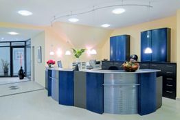 Moderne Rezeption mit gebogenem Tresen, blauen Schränken und Dekorationen in freundlichen Farben.