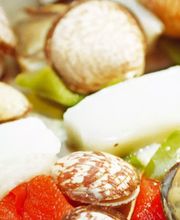 Plato de mariscos con almejas, calamares y pimientos rojos y verdes.