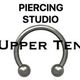 Afbeelding met tekst "Piercing Studio Upper Ten" en een cirkelvormige piercing.