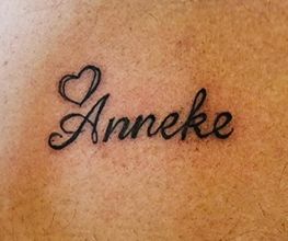 Tattoo met de naam "Anneke" en een getekend hart erboven.