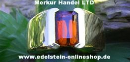 Goldring mit orangem Edelstein, Hintergrund aus Blättern und Holz. Text: Merkur Handel LTD, Website.