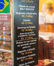 Placa de preços de self-service no restaurante No Horto, variando conforme o dia da semana.