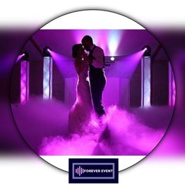 Un couple danse sous des lumières violettes, entouré de brume. Logo "Forever Event" en bas.