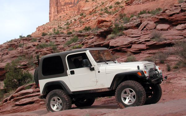 Ein weißer Jeep im steinigen Gelände  