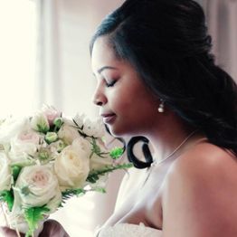 Bride holding white and pink bouquet, gazing softly.