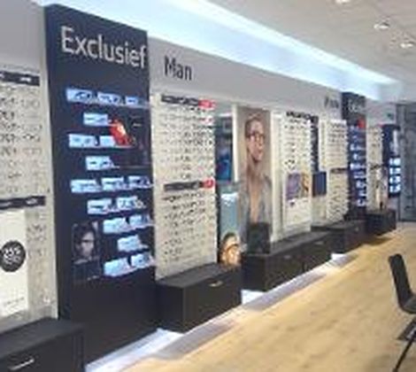 Brillenwinkelinterieur met displays voor exclusieve herenbrillen en stoelen voor oogmetingen.